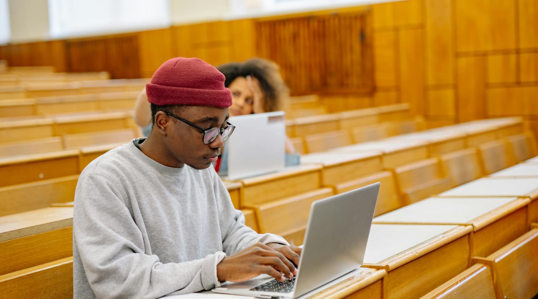 College students using laptops in a lecture hall while preparing for early-career work.