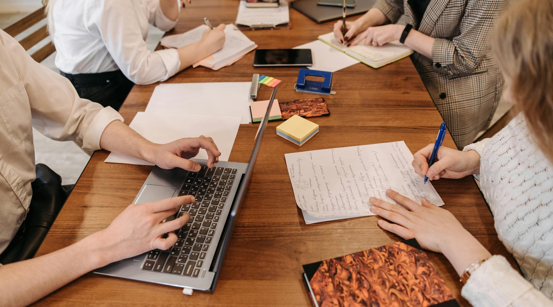 Career coaching notes, laptops, and documents arranged during a client planning session.